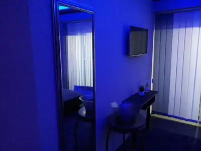 a blue room with a toilet and a mirror at Guest House Vila Salute in Niš