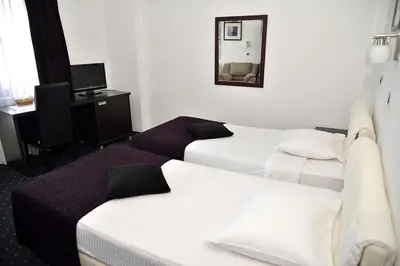 a hotel room with two beds and a mirror at Guest House Amico in Vranje