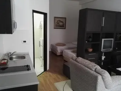 a living room with a sink and a living room with a mirror at Guest House Amico in Vranje