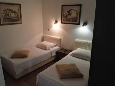 two beds in a small room with twoermottermott at Guest House Amico in Vranje