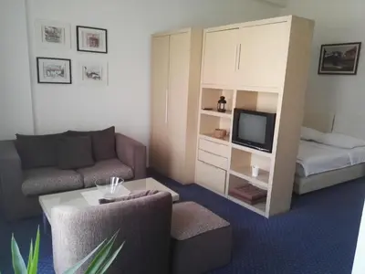 a small living room with a couch and a bed at Guest House Amico in Vranje