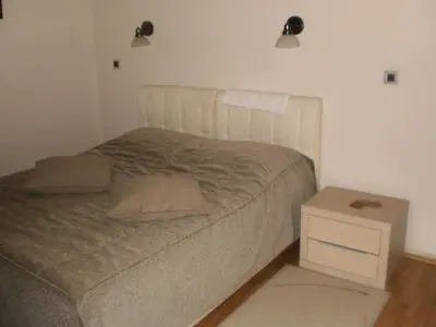 a bedroom with a bed and a night stand at Guest House Amico in Vranje