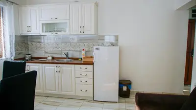 a kitchen with white cabinets and a white refrigerator at Apartment Petrović in Kopaonik
