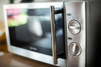 a microwave oven with the door open on a table at Holiday Cottage Pedja in Kopaonik