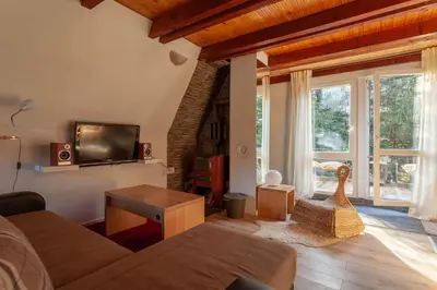 a living room with a couch and a tv at Holiday Cottage Pedja in Kopaonik