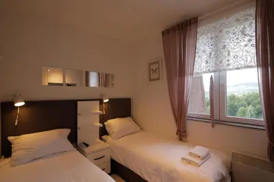 two beds in a bedroom with a window at Apartment Planinska Carolija in Kopaonik