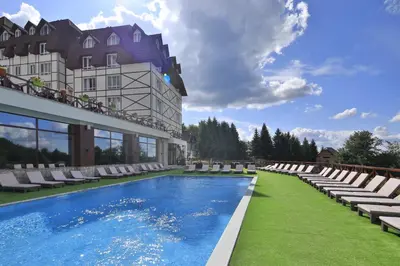 a hotel with a swimming pool and lounge chairs at Apartment Planinska Carolija in Kopaonik