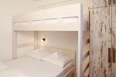 two white bunk beds in a small room at Apartment Planinska Carolija in Kopaonik