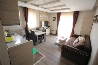 a small living room with a couch and a kitchen at Apartment G10 Milmari resort in Kopaonik