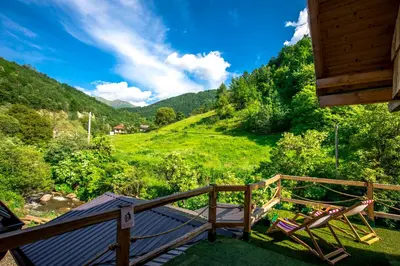 a deck with chairs and a view of a mountain at Šum Apartmani - Stara planina in Crni Vrh