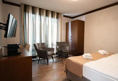 a hotel room with a bed and a desk and chairs at Hotel Vila San in Kopaonik