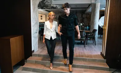 a man and a woman walking down the stairs at Hotel Vila San in Kopaonik