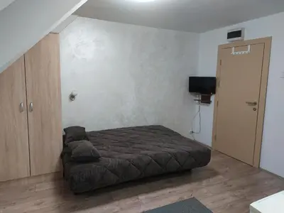 a small bedroom with a bed and a tv at Apartments Vila Djurdja in Kopaonik