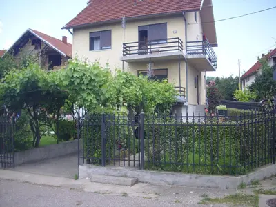 a house with a black iron fence in front of it at Guest House Nada in Soko Banja