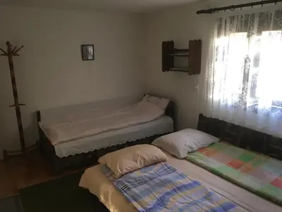 two twin beds in a room with a window at Guest House Nada in Soko Banja