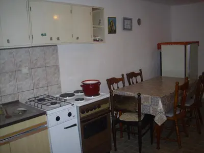 a kitchen with a stove and a table with a pot on it at Guest House Nada in Soko Banja