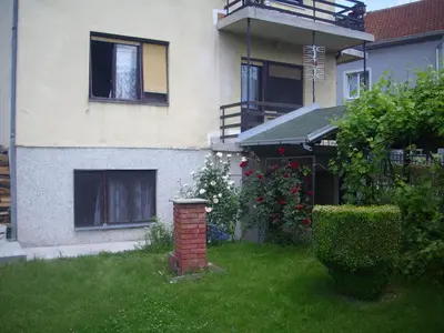 a house with a brick pillar in the yard at Guest House Nada in Soko Banja