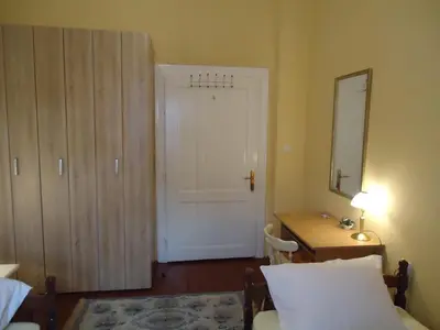 a bedroom with a bed and a mirror and a door at Apartments Villa Svetlana in Vrnjačka Banja