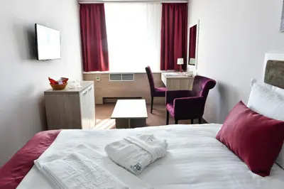 a hotel room with a bed with two towels on it at Hotel Ana Lux Spa in Pirot