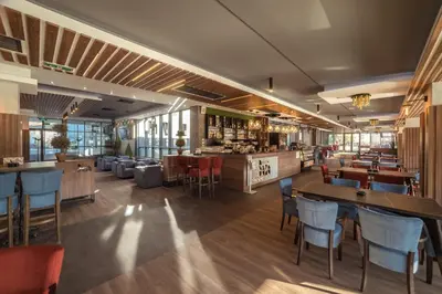 a restaurant with tables and chairs and a bar at Hotel Ana Lux Spa in Pirot