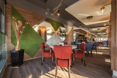 a dining room with a table and red chairs at Hotel Ana Lux Spa in Pirot
