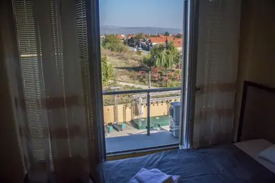 a room with a view of a bedroom with a window at Hotel Bella Nella in Leskovac