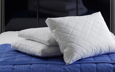 a stack of pillows sitting on top of a bed at Boulevard Apartments Cuprija in Ćuprija