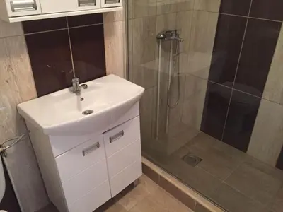 a bathroom with a white sink and a shower at Boulevard Apartments Cuprija in Ćuprija