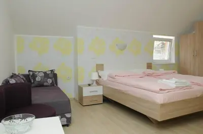 a bedroom with a bed and a chair in it at Apartments Kaskade in Soko Banja