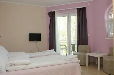 a bedroom with two white beds and a balcony at Apartments Kaskade in Soko Banja