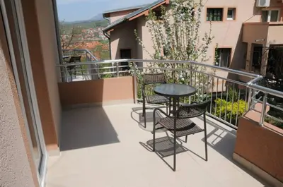 a balcony with chairs and a table on a balcony at Apartments Kaskade in Soko Banja