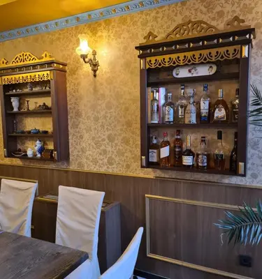 a restaurant with a bar with bottles on the wall at Garni Hotel & Spa Nicolo in Kruševac