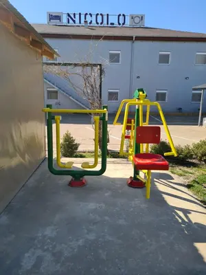 a playground with a slide in a parking lot at Garni Hotel & Spa Nicolo in Kruševac