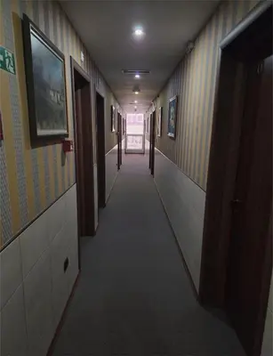 a hallway with a long corridor with doors and a long corridorngthngthngthngth at Garni Hotel & Spa Nicolo in Kruševac