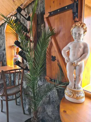 a statue of a little boy sitting on a table at Garni Hotel & Spa Nicolo in Kruševac