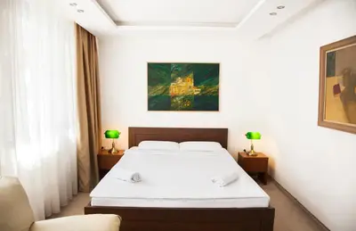 a bedroom with a bed and a painting on the wall at Hotel Happy in Dimitrovgrad
