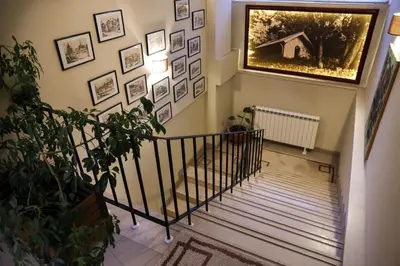 a hallway with a staircase with pictures on the wall at Hotel Happy in Dimitrovgrad