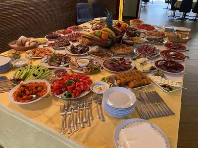 a table topped with plates and bowls of food at Hotel Happy in Dimitrovgrad