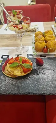 a table with a plate of food and plates of pastries at Garni Hotel Zen free parking in Niš