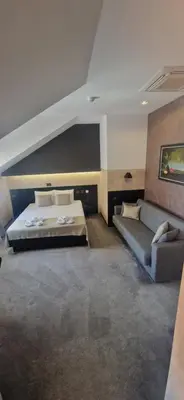 a bedroom with a bed and a couch at Garni Hotel Zen free parking in Niš