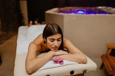 a woman laying in a bath tub with a flower at Garni Hotel Zen free parking in Niš