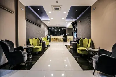 a waiting room with green chairs and a bar at Garni Hotel Zen free parking in Niš