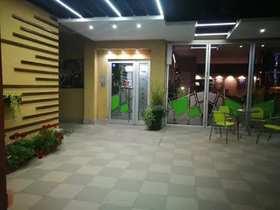 a lobby with green chairs and a glass door at Bed & Breakfast Park Gate in Vranje
