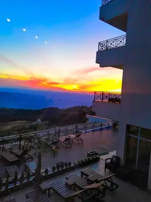 a view of a sunset from a balcony of a building at G4 Apartment Milmari in Kopaonik