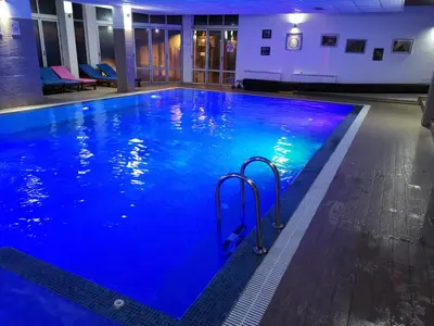 a large swimming pool with blue water in a building at G4 Apartment Milmari in Kopaonik