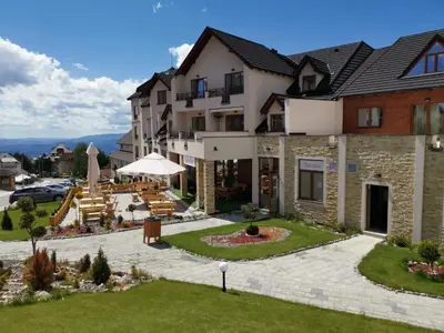 a building with a patio and tables and chairs at G4 Apartment Milmari in Kopaonik