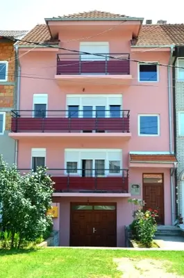 a pink building with two balconies on it at Guest House Trajkovic Jagodina in Jagodina