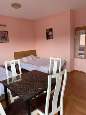 a dining room with a table and chairs and a bed at Guest House Trajkovic Jagodina in Jagodina