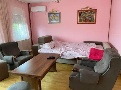a living room with a bed and a table and chairs at Guest House Trajkovic Jagodina in Jagodina