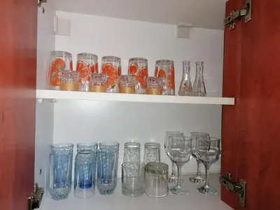 a shelf filled with glasses and wine glasses at Apartman Centar in Kruševac